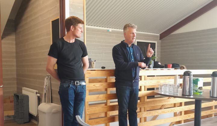 två män står vända mot en publik och berättar om gårdens verksamhet.