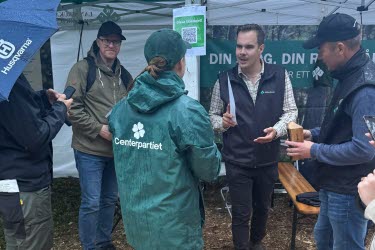 Personer i en monter, en med jacka från Centerpartiet
